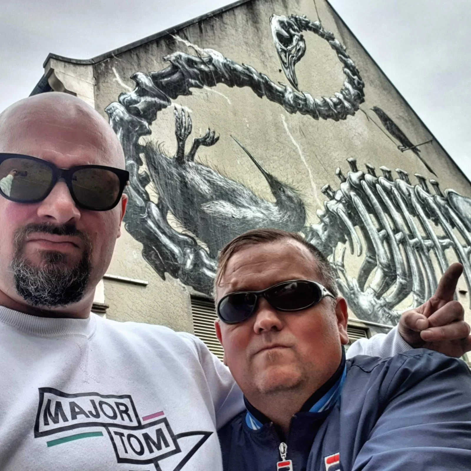 Selfie of Yann and a friend in sunglasses in front of a giant ROA mural in Christchurch