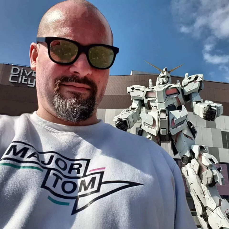 Yann in een Major Tom-trui voor het levensgrote Gundam-robotbeeld aan DiverCity Tokyo