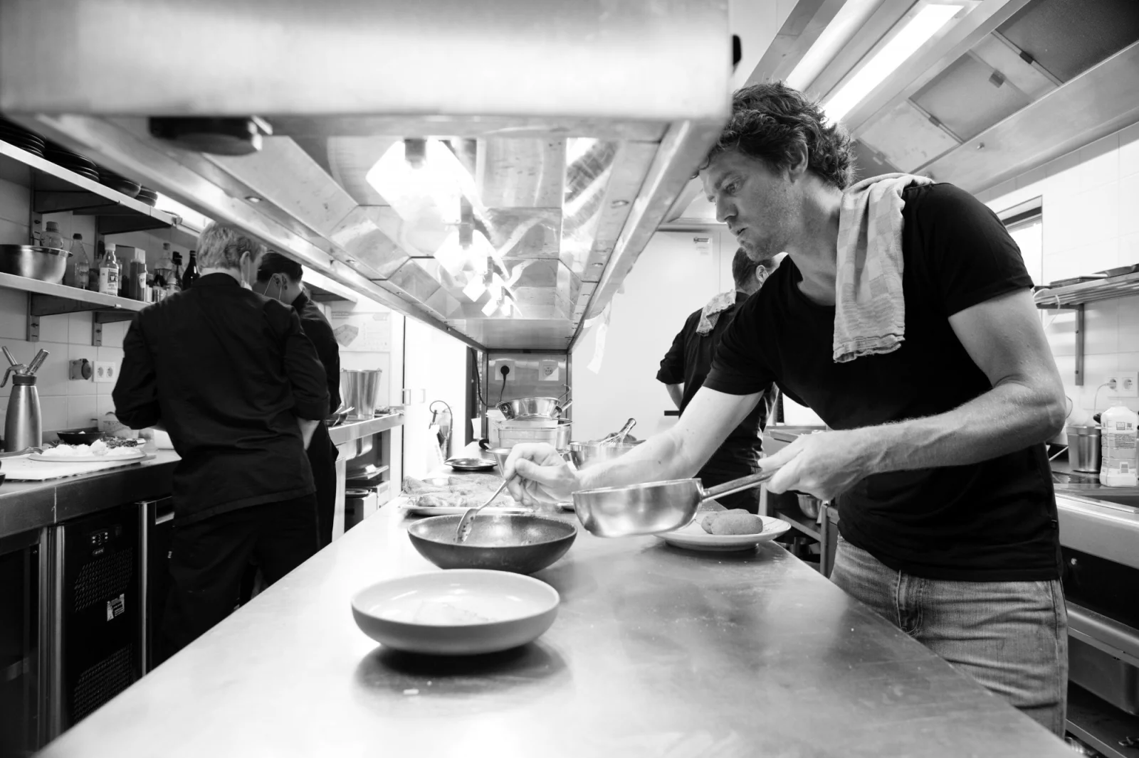 Chef aan het werk in de keuken van Fou du Go&ucirc;t, in zwart-wit
