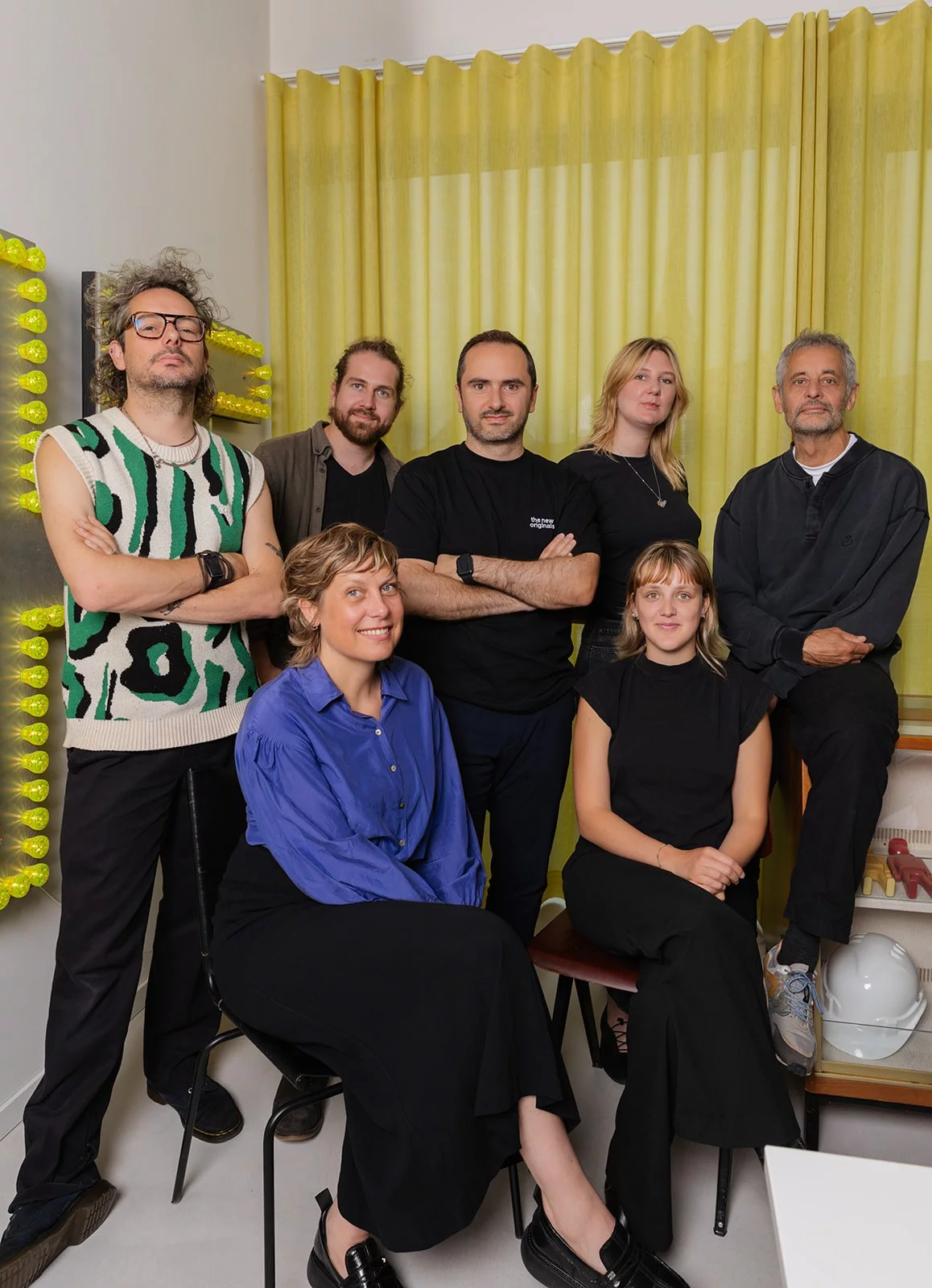 The Pi&egrave;ce Mont&eacute;e team in their studio in Ghent, in front of a wall of yellow light-up letters